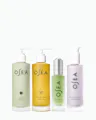 Four OSEA skincare bottles arranged in a row against a clean white background: ocean cleanser in a pale sage pump bottle, undaria algae body oil in a translucent golden yellow pump bottle, hyaluionic sea serum in a light green dropper bottle with a silver cap, and cream bio-retinol body serum in a pale lavender pump bottle.