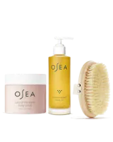 OSEA Undaria Algae™ Body Oil, Salts of the Earth Body Scrub and dry body brush arranged on white background