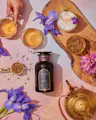 Magic Hour Lucid Dreams ceremonial tea jar with brewed tea, loose ingredients, flowers, and teapot on pink background