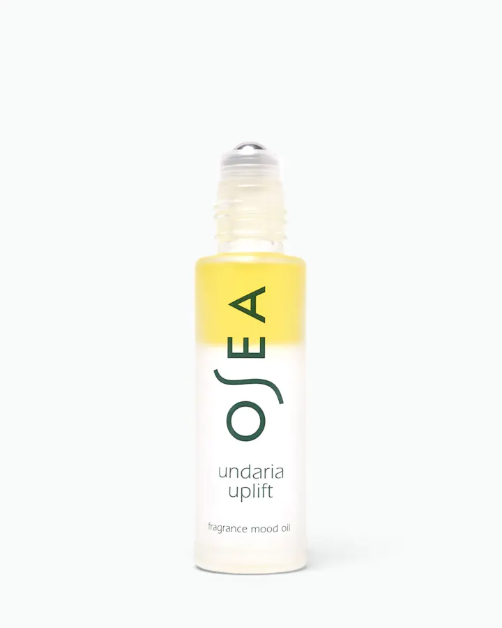 A bottle of OSEA Undaria Uplift fragrance mood oil with a yellow-to-clear gradient label and a clear rollerball cap, centered on a white background.