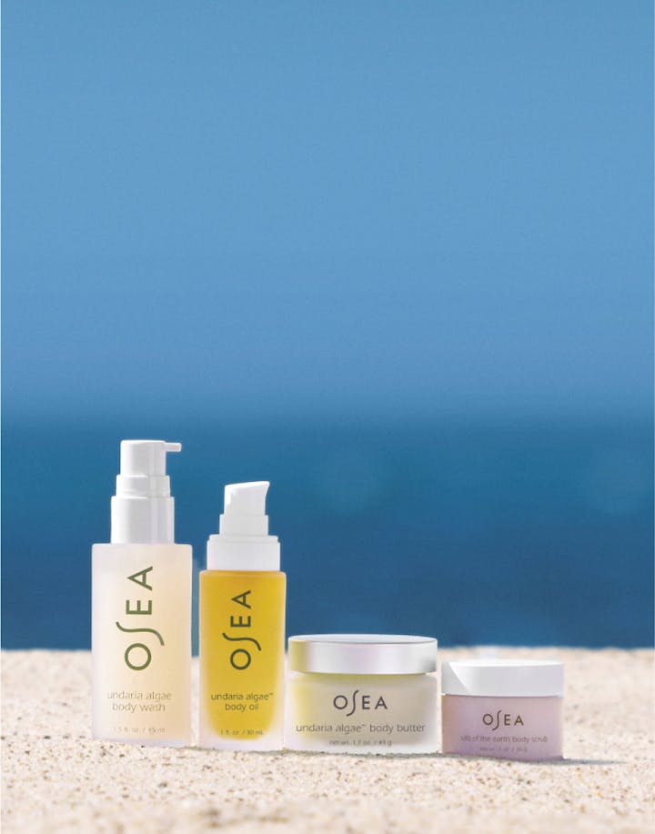 OSEA skincare products on a beach with ocean in the background