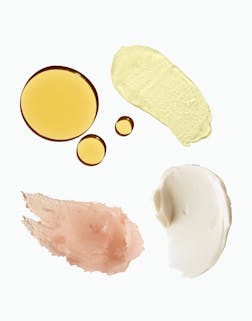 Various cosmetic textures including oil, cream, and lotion on a white background