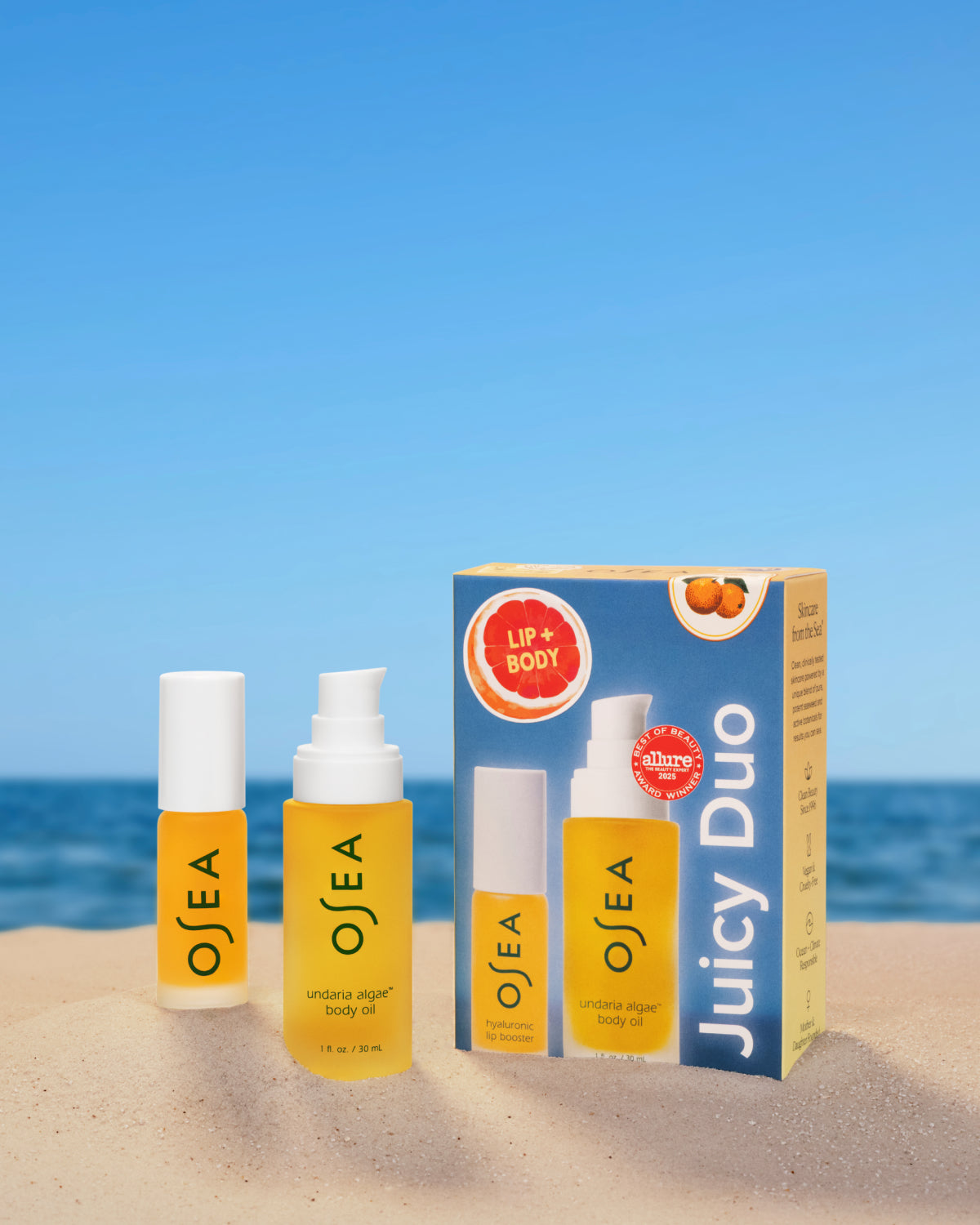 OSEA skincare products with a Juicy Duo box on a beach