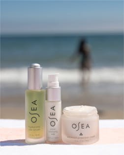 OSEA Ritual Reset Bundle (3 products) placed on a beach with ocean background