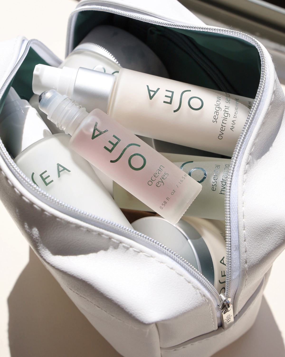 OSEA skincare products in a white makeup bag