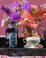 Magic Hour Lucid Dreams herbal tea jar beside a floral arrangement and ornate teacup on a tray