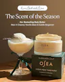 Open jar of OSEA Undaria Algae Body Butter in Bergamot & Vanilla Bean atop its limited edition packaging box, styled outdoors against a blue sky and ocean horizon with a ribboned gift box beside it.