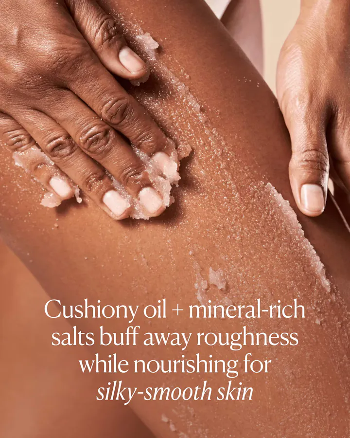 Person scrubbing their leg with a cushiony oil and mineral-rich salt product.