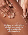 Person scrubbing their skin with a cushiony oil and mineral-rich salt product.