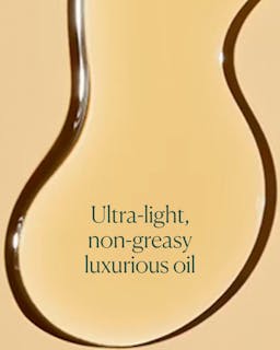 Close-up of a droplet of ultra-light, non-greasy luxurious oil with text overlay on a beige background.