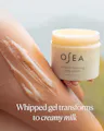 OSEA body polish jar with whipped gel on skin, text 'Whipped gel transforms to creamy milk'.