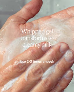 Hand applying whipped gel that transforms into a creamy milk, with text on transformation and usage frequency.