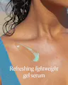 Close-up of OSEA Hyaluronic Body Serum's mint-green gel texture swiped onto skin near the collarbone, with text reading 'Refreshing lightweight gel serum.