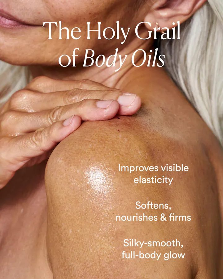 Close-up of a hand smoothing oil onto a shoulder, with text reading 'The Holy Grail of Body Oils: Improves visible elasticity, softens, nourishes & firms, silky-smooth full-body glow.'
