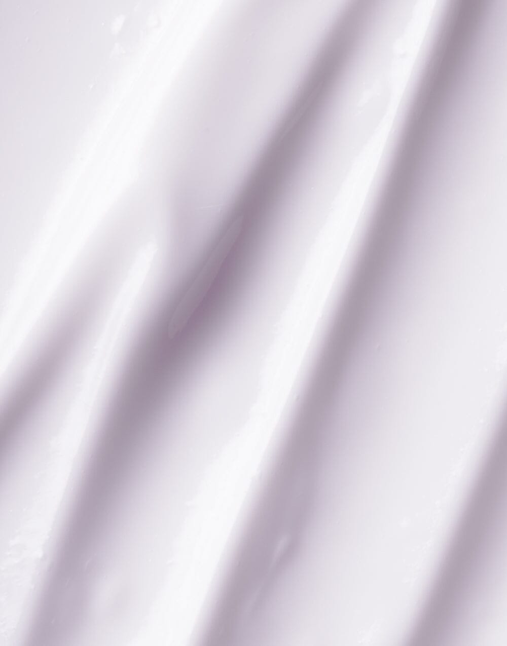 Swirl of OSEA Dream Night Cream texture on a lavender silk-like surface