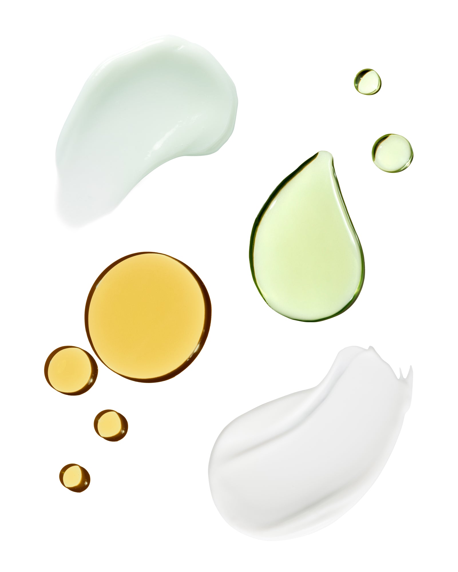 Various droplets of oil and cream on a white background