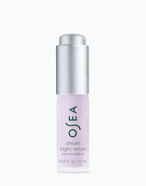 A small bottle of OSEA dream night serum with a purple label and a silver cap.