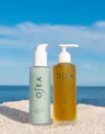 Hyaluronic Body Serum and Undaria Algae Body Oil displayed on sand with ocean backdrop