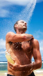 Man showering with Undaria Algae Body Wash on the beach