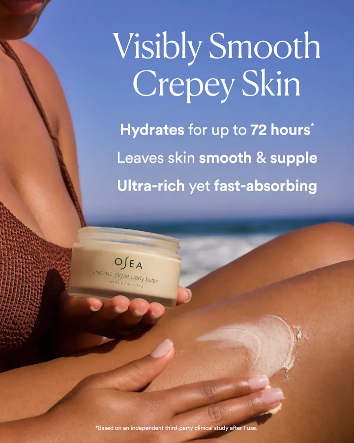 Person applying OSEA body cream on their leg with a beach background