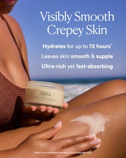 Person applying OSEA body cream on their leg with a beach background