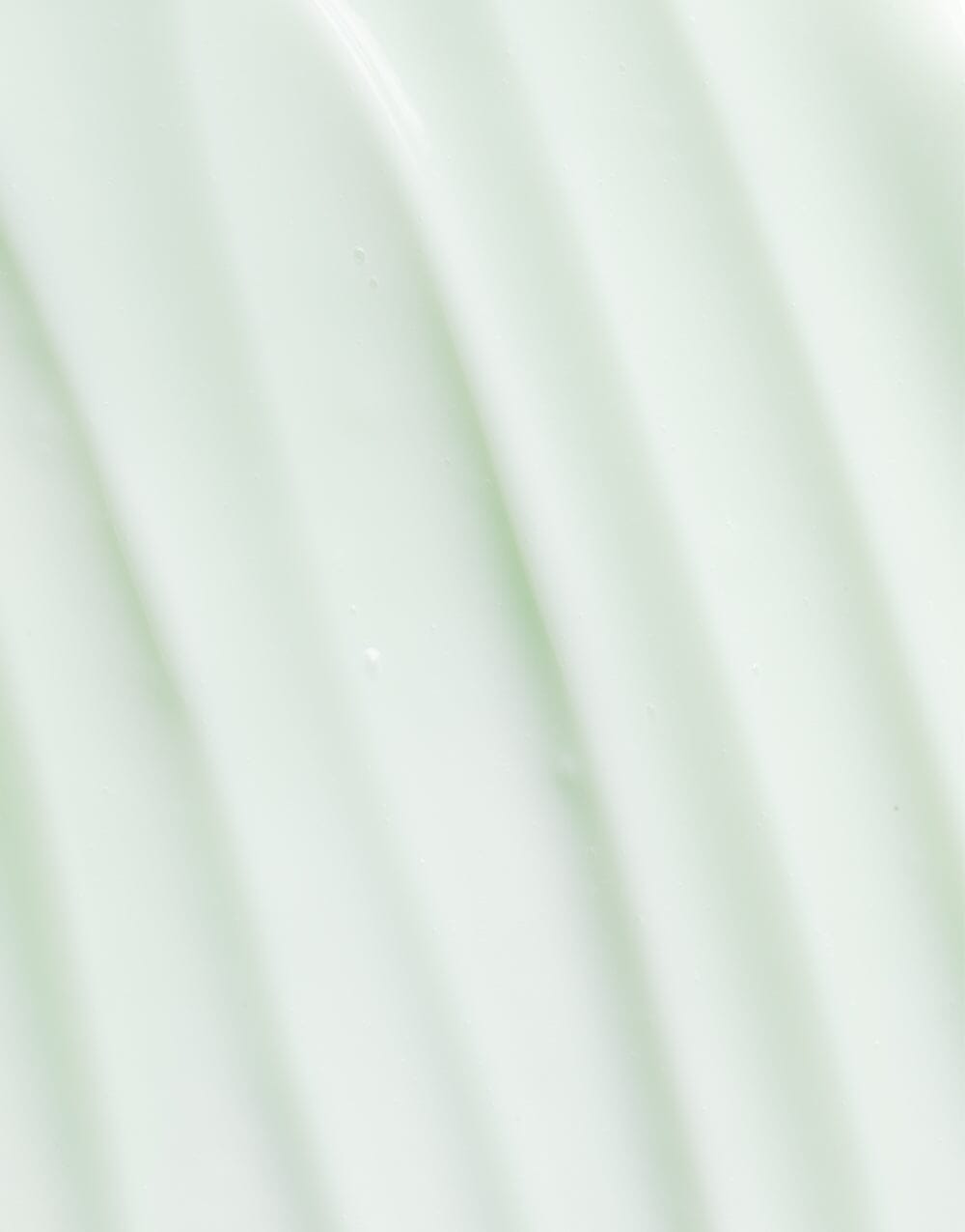 OSEA Ocean Cleanser bottle on soft gradient mint green background with vertical ripples