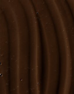 Close-up of rich, dark brown Ocean Cleansing Mudd texture with wavy surface pattern