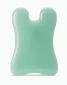 Mint green OSEA facial sculpting tool (gua sha–style) on white background