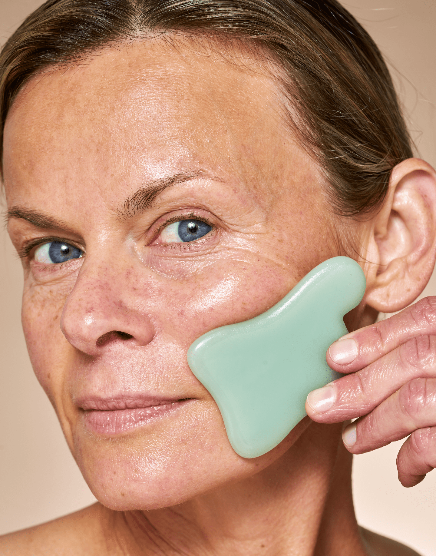 Woman Uses A Green Facial Tool