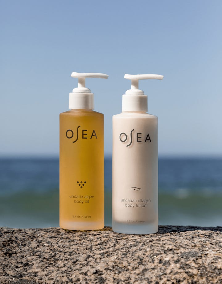 Undaria Algae™ Body Oil and Undaria Collagen Body Lotion displayed seaside, emphasizing nourishing, glow-enhancing benefits