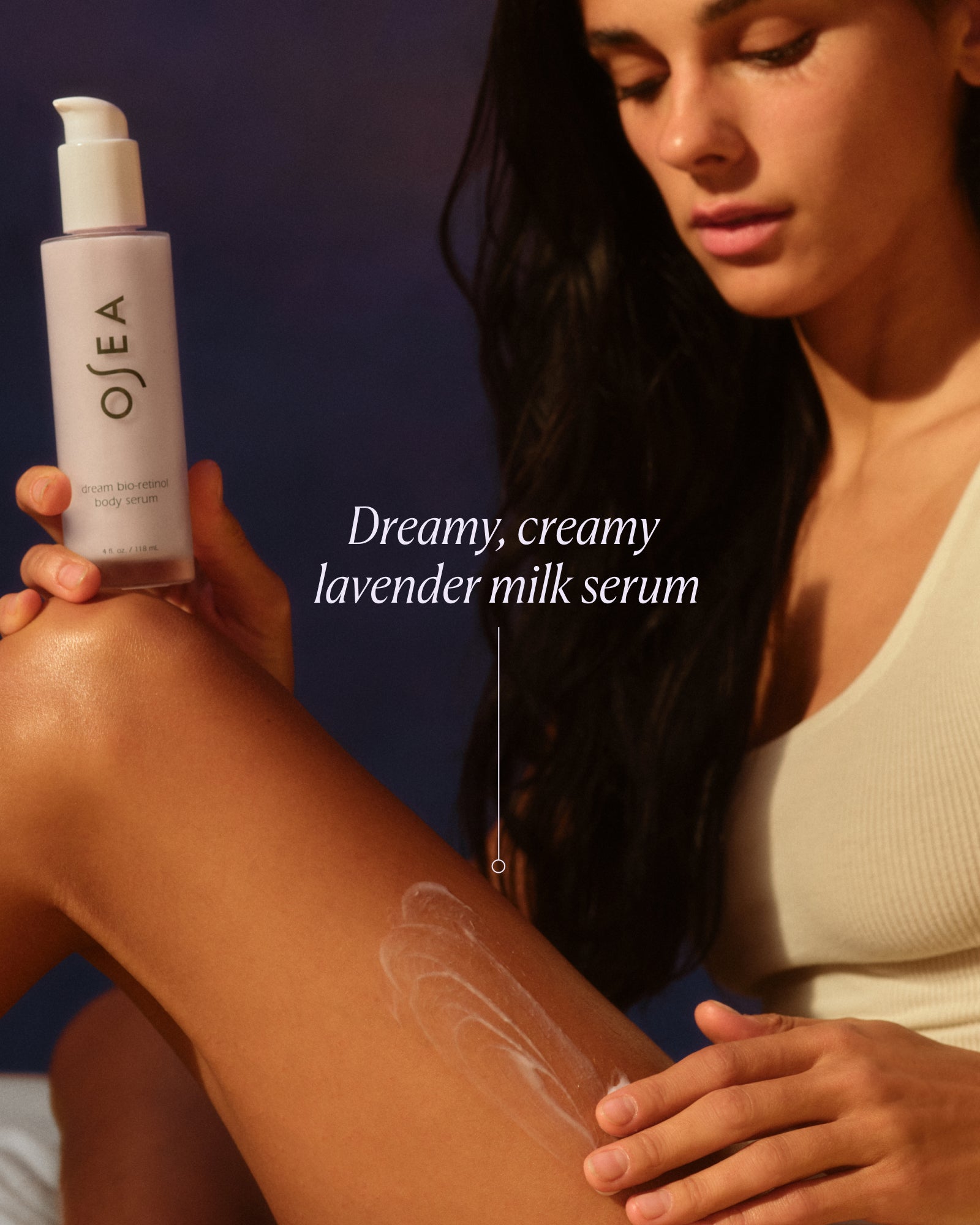 Woman applying Osea lavender milk serum to her arm with a dark background