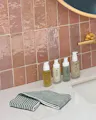 Striped reusable facial cloth on bathroom counter beside OSEA skincare products