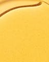 Golden body oil texture close-up showing lightweight, nourishing consistency
