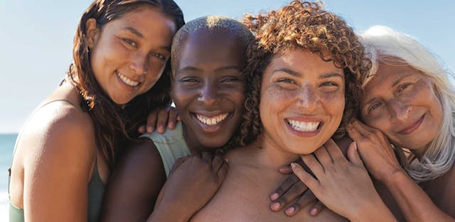 A Group Of Women Posing For A Photo On The Beach