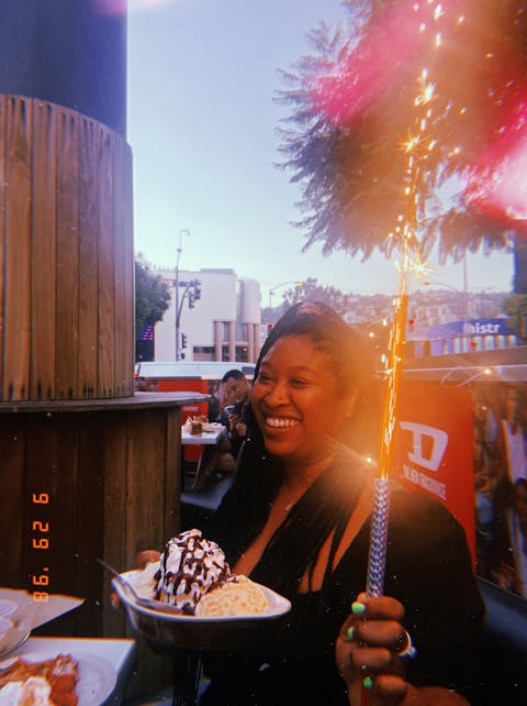 A Woman Holding A Plate Of Ice Cream And A Sparkler
