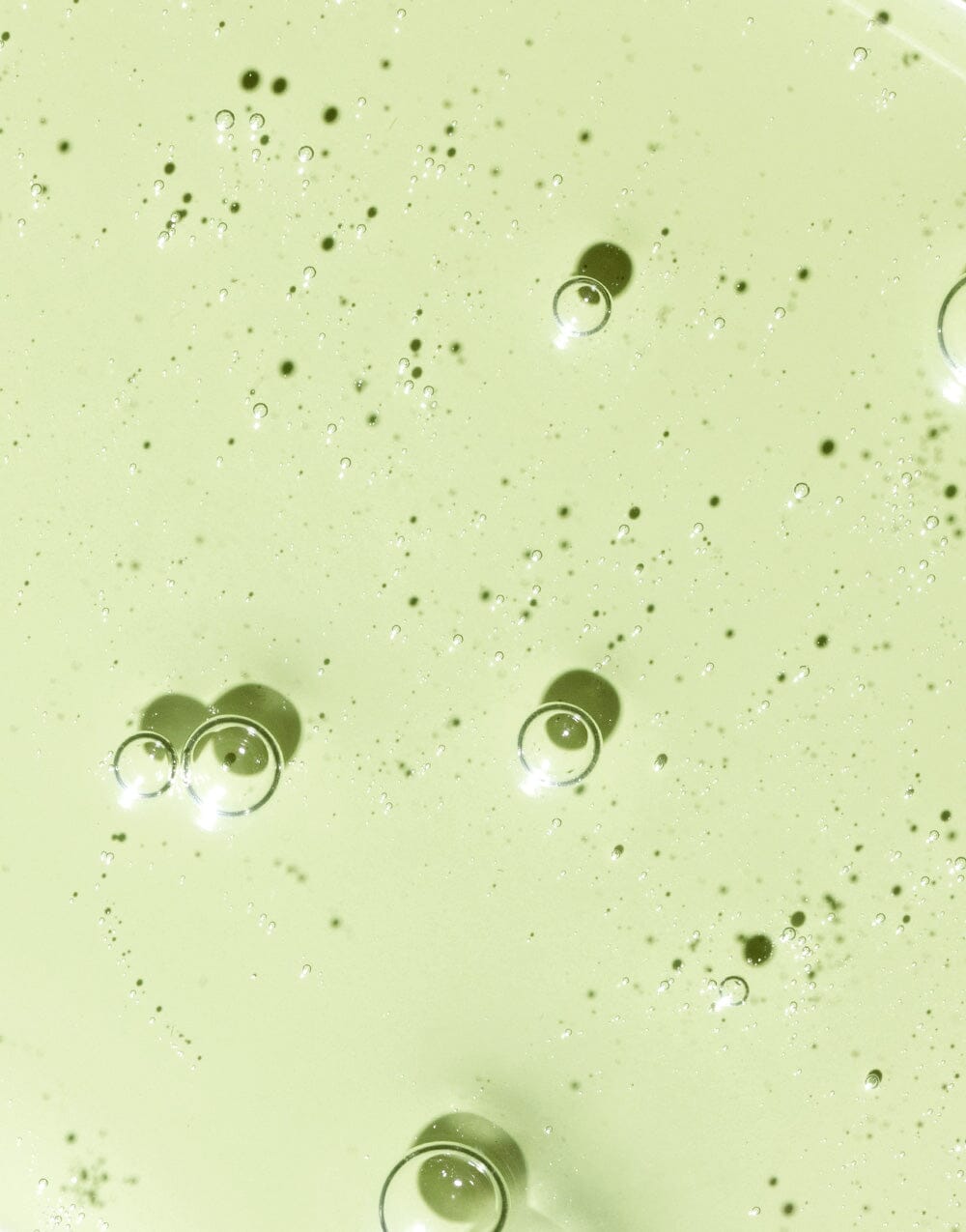 Swatch of Hyaluronic Sea Serum with visible suspended micro-droplets on light surface