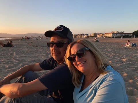 A Man And Woman On The Beach At Sunset