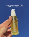 Dayglow Face Oil applied to skin, showing lightweight golden texture absorbing for an instant dewy glow