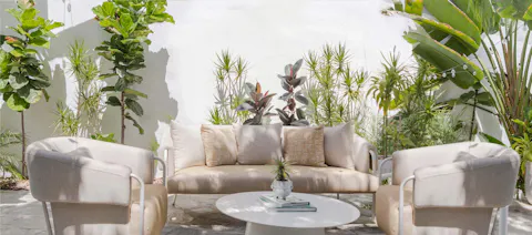 A Patio With White Furniture And Plants