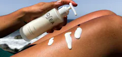 Woman Putting Lotion On Her Leg