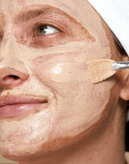 Model applying Red Algae Clarifying Mask with visible cooling texture on face