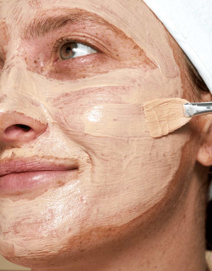 Model applying Red Algae Clarifying Mask with visible cooling texture on face